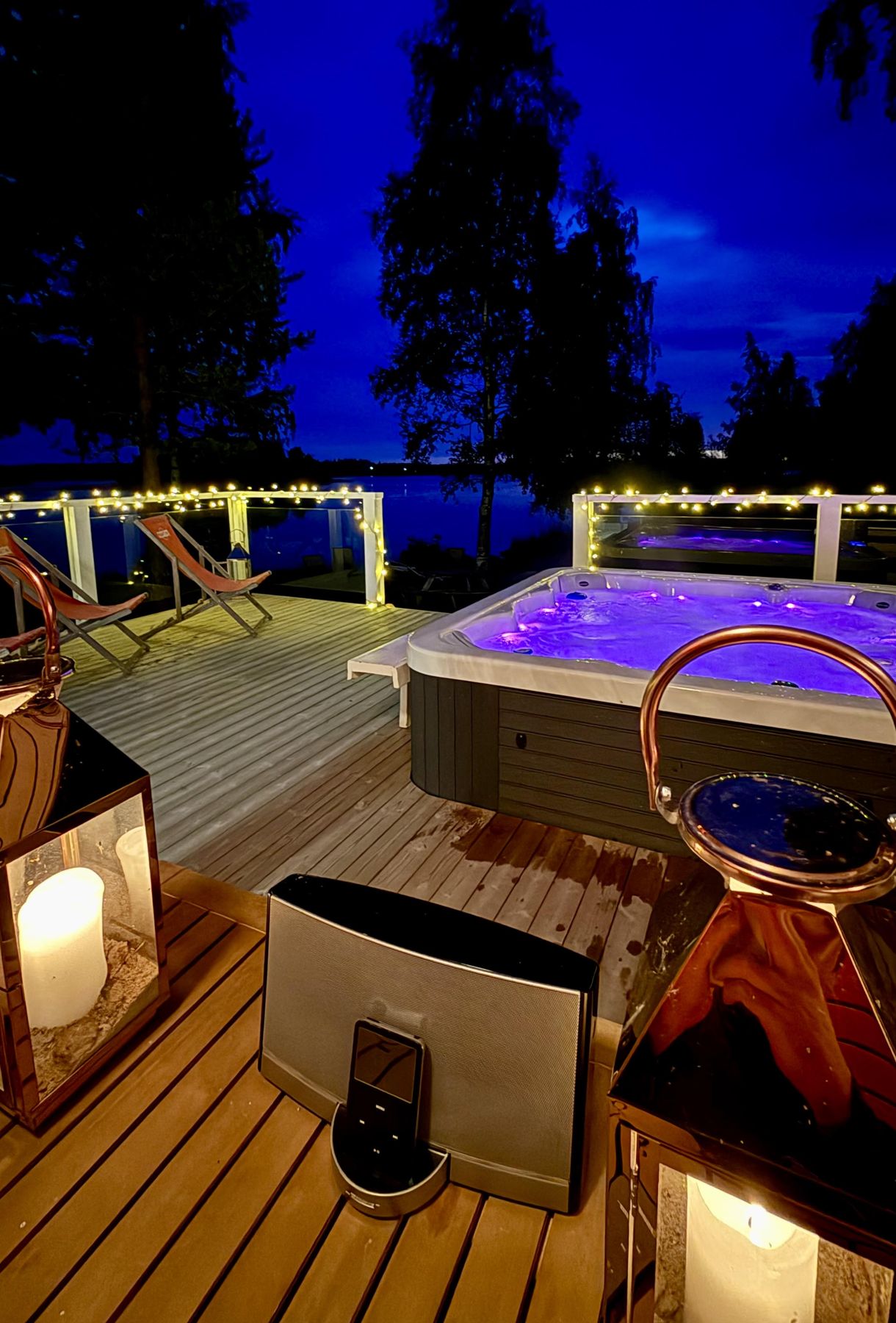 The lit outdoor hot tub in the evening at Halosenniemi