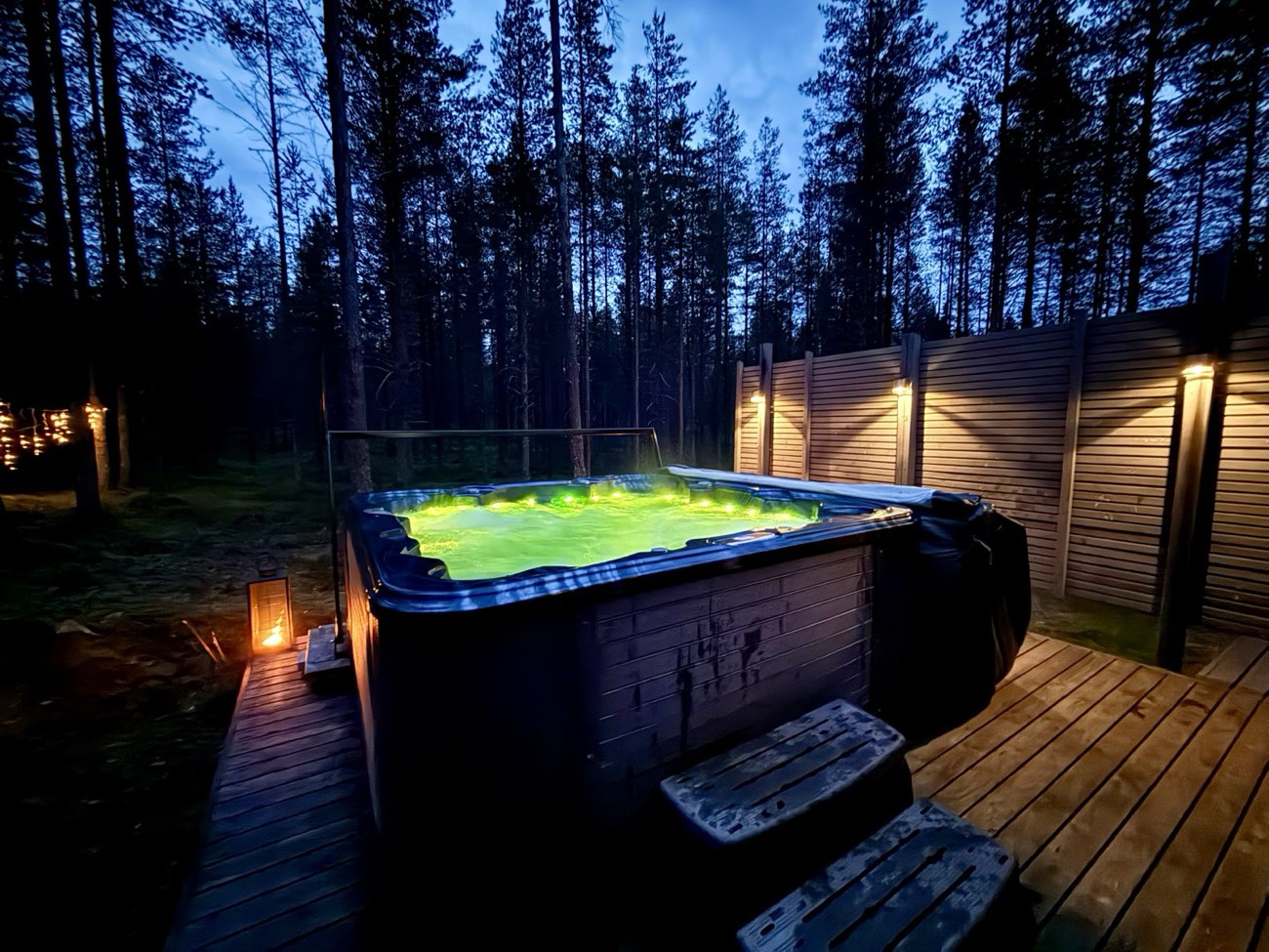 Valaistu ulkoporeallas illalla mäntymetsän keskellä